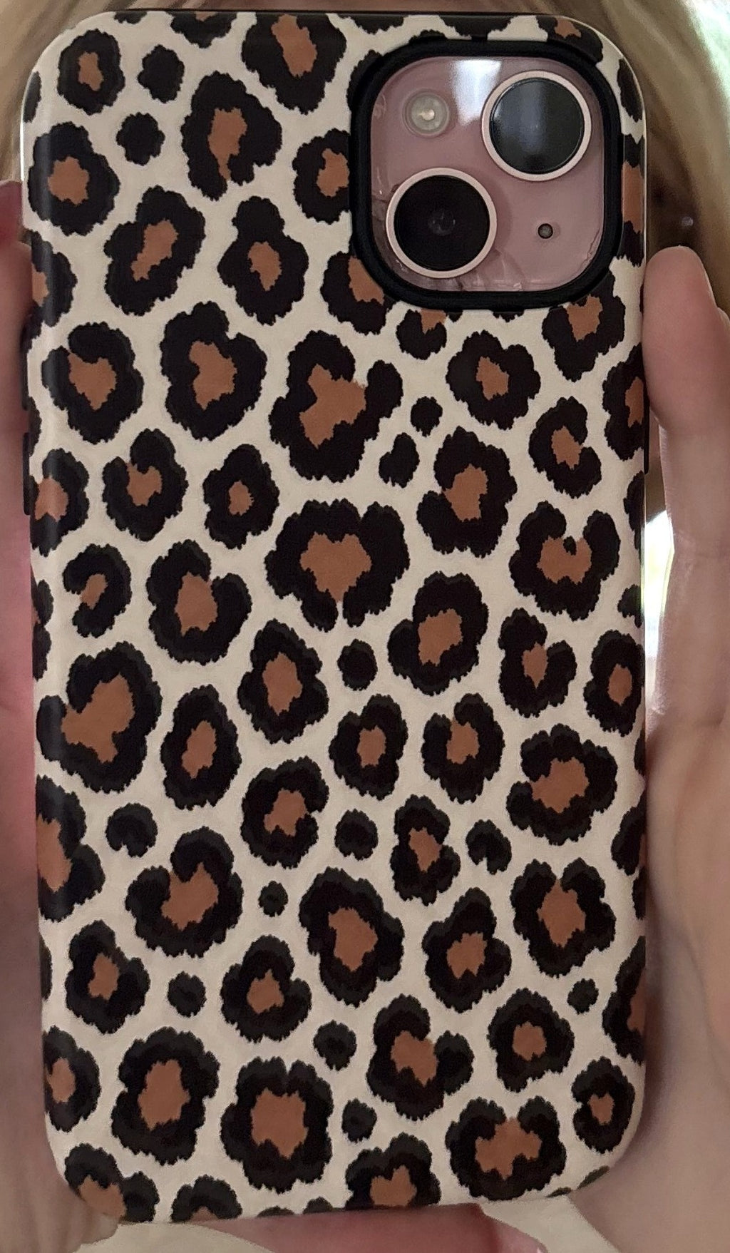 Leopard print phone case on iPhone, held in hand